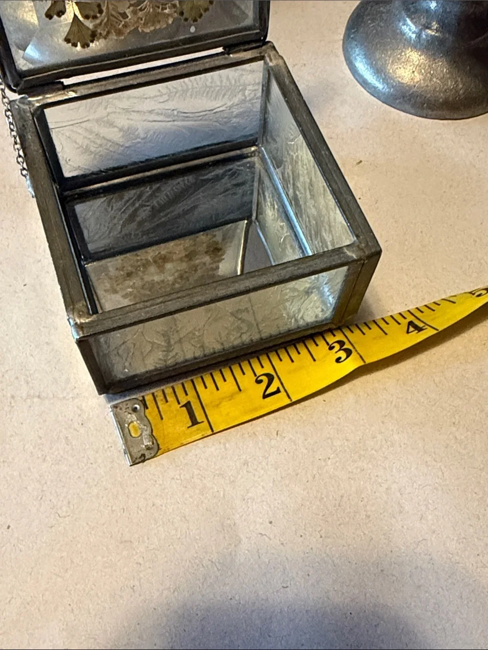 Vintage trinket box with metal edges and dried flowers on top. Mirror bottom.